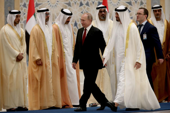 Russian President Vladimir Putin walks with Abu Dhabi's Crown Prince Mohammed bin Zayed Al-Nahyan during a welcome ceremony at the Presidential Palace in Abu Dhabi
